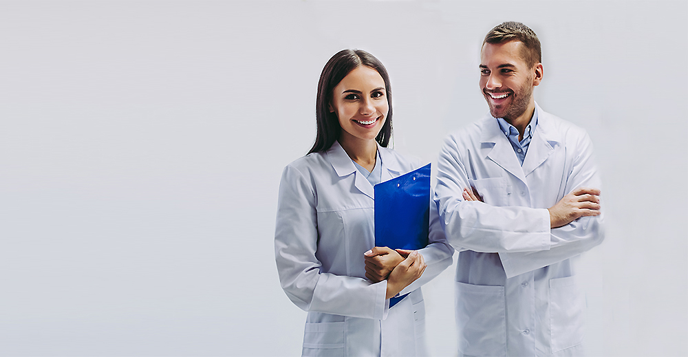 The image shows two individuals, a man and a woman, standing in front of each other with one holding a blue folder. They are both dressed in professional attire commonly associated with healthcare professionals, such as white coats and stethoscopes. They appear to be in an indoor setting with a plain background.