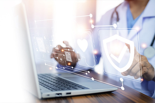 The image shows a healthcare professional using a laptop with a digital interface that includes various icons related to health and security, while the individual is holding a tablet displaying similar themes.