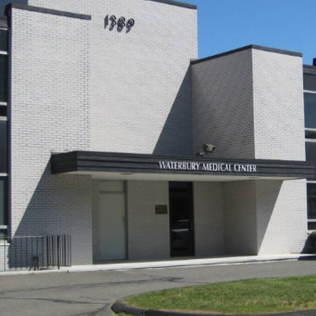 The image depicts a building with a sign that reads 'WATERBURY MEDICAL CENTER' and the number '1969' above the entrance.