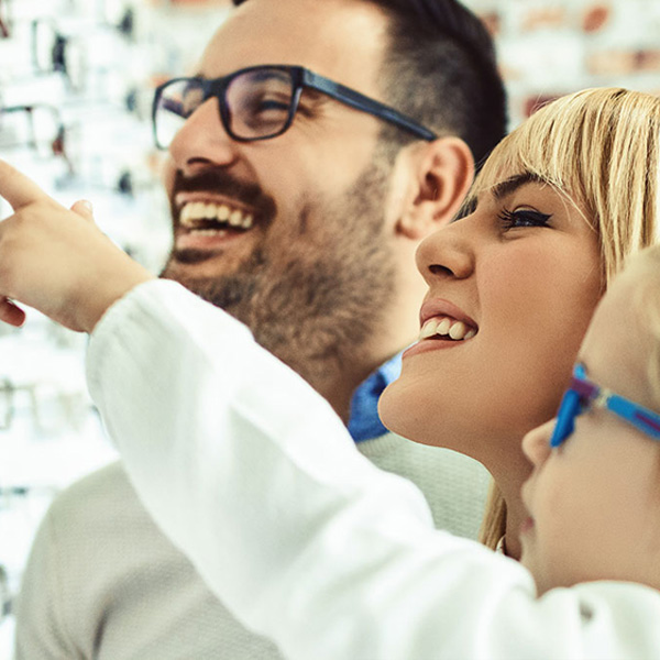 A family in a store, with the parents pointing at items and their child looking onward.
