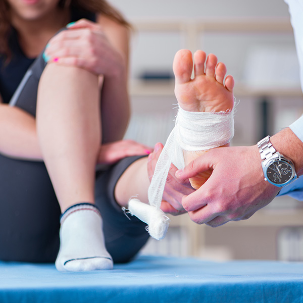 An image featuring a person with an injured foot, receiving medical attention from a healthcare professional.