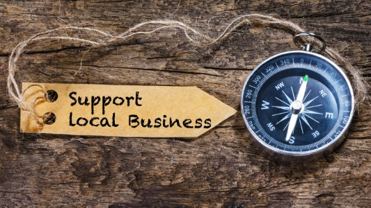 The image features a compass with a directional arrow pointing to the right, accompanied by a rope and a tag that reads 'SUPPORT LOCAL BUSINES.