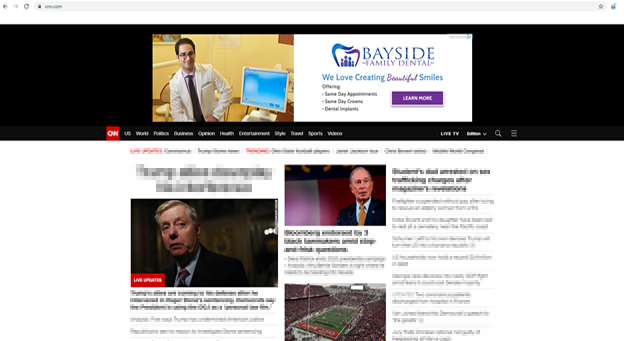 The image shows a screenshot of a computer monitor displaying a webpage with news articles and a television screen broadcasting a news program featuring a male anchor.