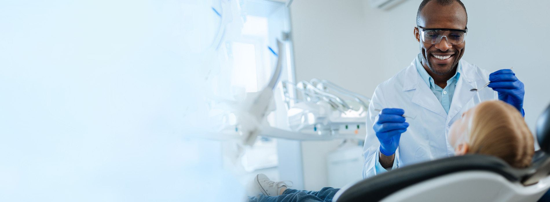 A dental professional in a sterile environment, interacting with a patient s mouth.