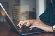 A woman typing on a laptop with a digital display showing a 5-star rating and the number '6'.