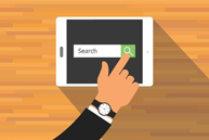 A hand pointing to a tablet screen displaying a search bar with the word 'search' highlighted, against a blurred background of what appears to be a wooden floor.