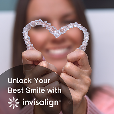 The image features a person holding up a clear, heart-shaped aligner with the text 'Unlock your best smile with Invisalign' overlaid on it.