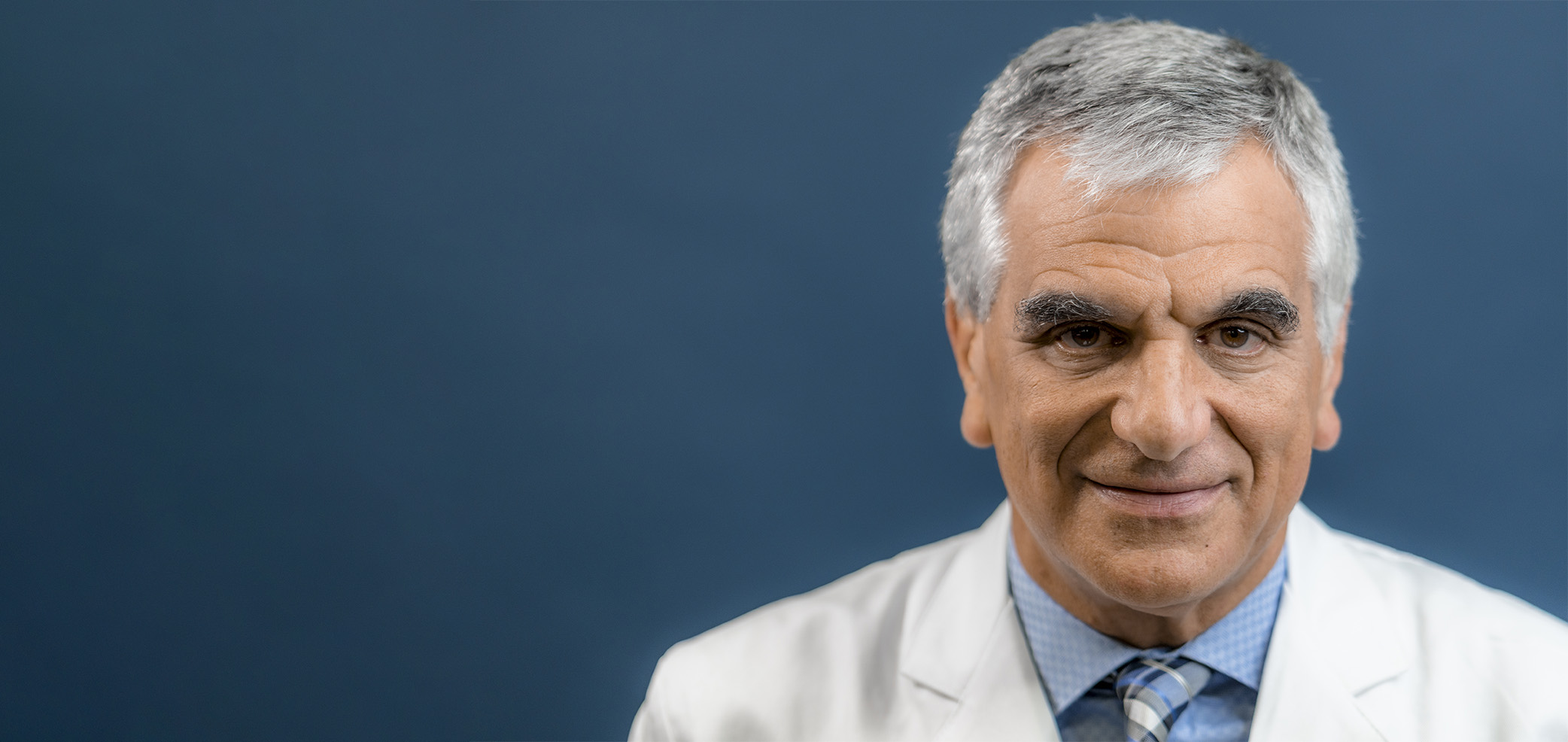 The image features a man in a lab coat, likely a scientist or doctor, with a serious expression, set against a blurred background.
